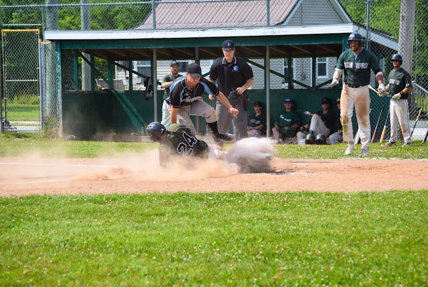 The Hantsport Shamrocks watched in anticipation as Adrian Lloy rounded third base and made a run for home plate. He slid into home in a cloud of dust as Schooners’ pitcher Justyn Newell tried to tag him out.