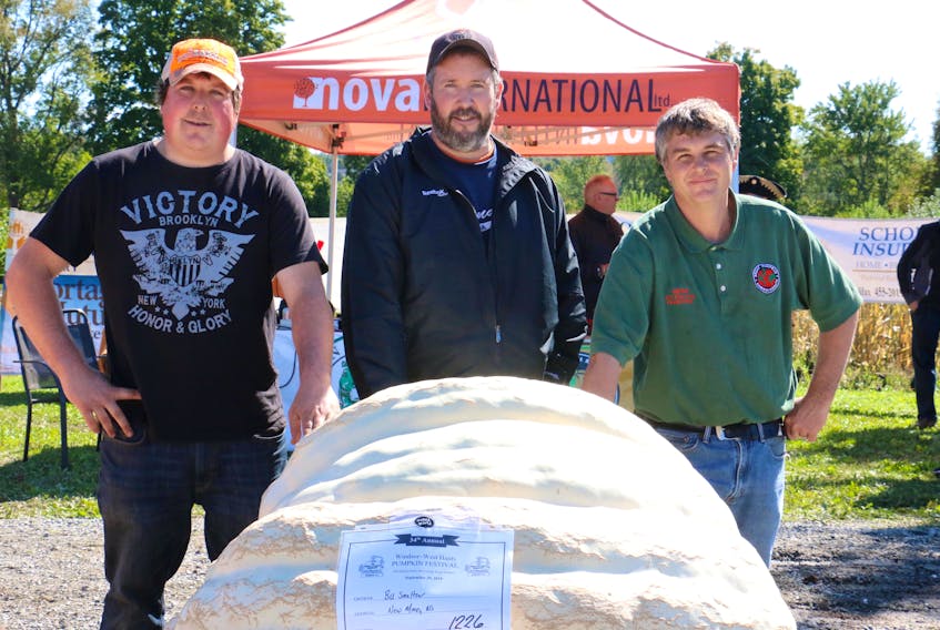 Bill Smeltzer, flanked by Jeremy Zwicker, left, and Jeff Reid, won the 34th annual Windsor West Hants Pumpkin Weigh-off. His giant pumpkin weighed in at 1,226 pounds (556 kg).