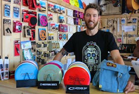 Tony Wood, co-owner of the Spoke & Note on Water Street in Windsor, displays the typical equipment required to play disc golf. The store sells and rents the gear, with a full-day rental costing $5.
