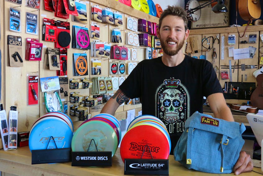 Tony Wood, co-owner of the Spoke & Note on Water Street in Windsor, displays the typical equipment required to play disc golf. The store sells and rents the gear, with a full-day rental costing $5.