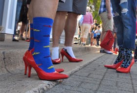 New Minas rotary president Mark Vardy, left, said, “if this is really what we think is the epitome of female fashion, there is clearly something wrong,” as he walked in his red stilettos.