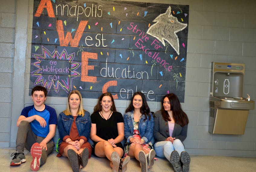 Annapolis West Education Centre students sit by the Wall of Positivity at the school. They are members of Heather Hiscock’s Sociology 12 class that is hoping to make the world a better place through messages of positivity, kindness clinics, and such inclusive activities as paining a rainbow crosswalk.