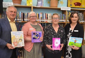 Kings West MLA and Communities, Culture and Heritage Minister Leo Glavine, Annapolis Valley Regional Library community engagement co-ordinator Angela Reynolds, Cindy Roberts and Annapolis Valley Regional Library CEO Ann-Marie Mathieu with some of the cancer resource books for kids purchased through a fundraiser by the Western Valley Spartans Pee Wee AA hockey team. - Kirk Starratt