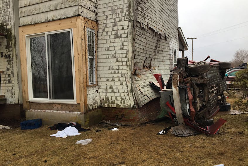 Two people in this car and a woman in the house were taken to hospital Saturday morning after the car left the road, pitchpoled and crashed into the side of the building.