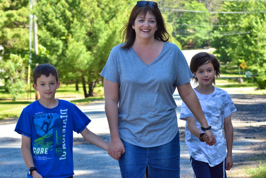 Ravenwood resident Denise Francis, pictured with the eight-year-old twins Parker and Aiden, is deeply concerned about impending changes that will result in the elimination of several school  bus stops within the busy subdivision.