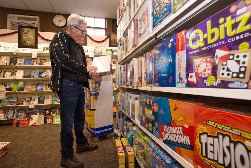 Murray McLean looks through the large selection of puzzles for a gift while shopping in Chisholm's in Kentville.