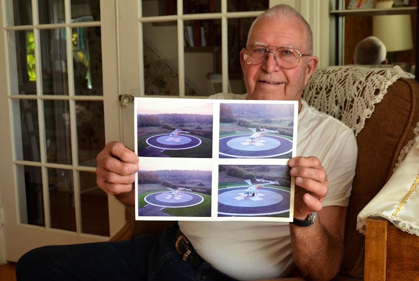 Ron Brown holds photos of a helicopter on the helipad at Soldiers Memorial Hospital in Middleton. The photos were part of a package during the official opening of the helipad on Oct. 22, 2000. Brown was in charge of building the pad and 18 years later it played a part in saving his life.