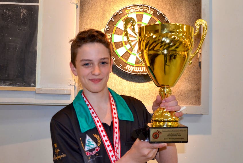 Darts prodigy Cohen Campbell shows off his first-place trophy for the Junior Male Singles Championship.