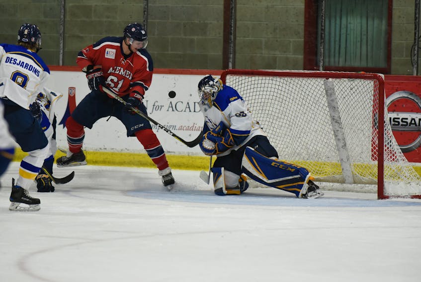Marc McNulty looks at loose puck in front of Moncton’s Montpetit.