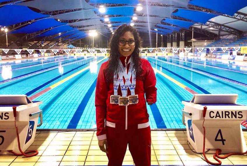 Katraina Roxon wears the three medals — gold, silver and bronze — she won over the past week at 2018 Pan Pacific Para swimming championships in Cairns, Australia.
