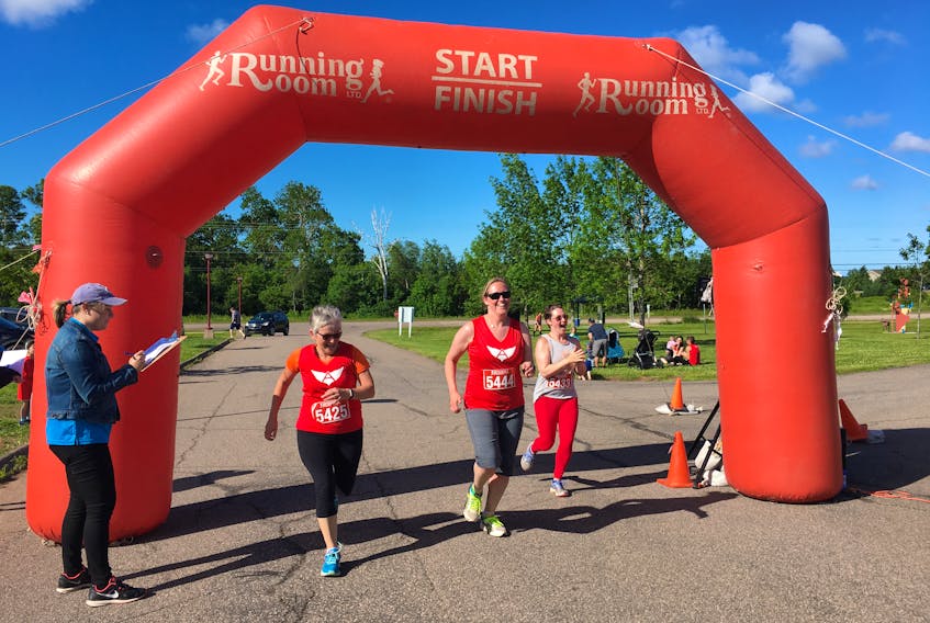 Kensington Learn to Run Program members, from left, Cheryl Noonan, Courtnay Woods and Nicole Sellar cross the finish line Saturday at the third annual Michael Thomas Race Day in Stratford.