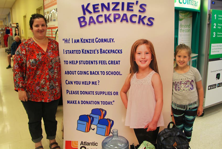 Eight-year-old Kenzie Gormley stands beside a large sign in the Antigonish Atlantic Superstore which promotes the program she started to help families in need with school supplies. Kenzie’s mom Sherise Pettipas is the administrator of Kenzie’s Backpacks which, this year, has expanded to help families in Port Hawkesbury, New Glasgow and Truro.