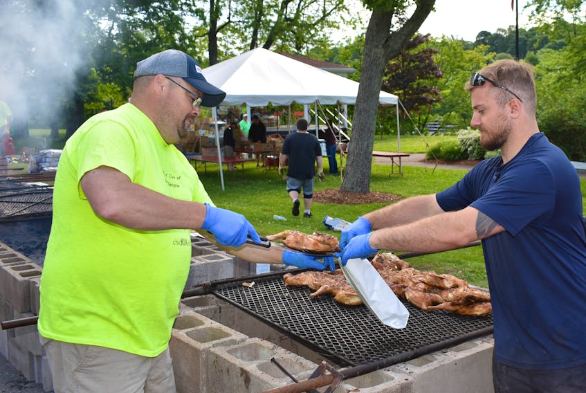 Tony Hessian, left, and Ryan Camp were busy packaging chicken hot off the barbecue at the annual Kinsmen Chicken BBQ on Friday, July 13.
