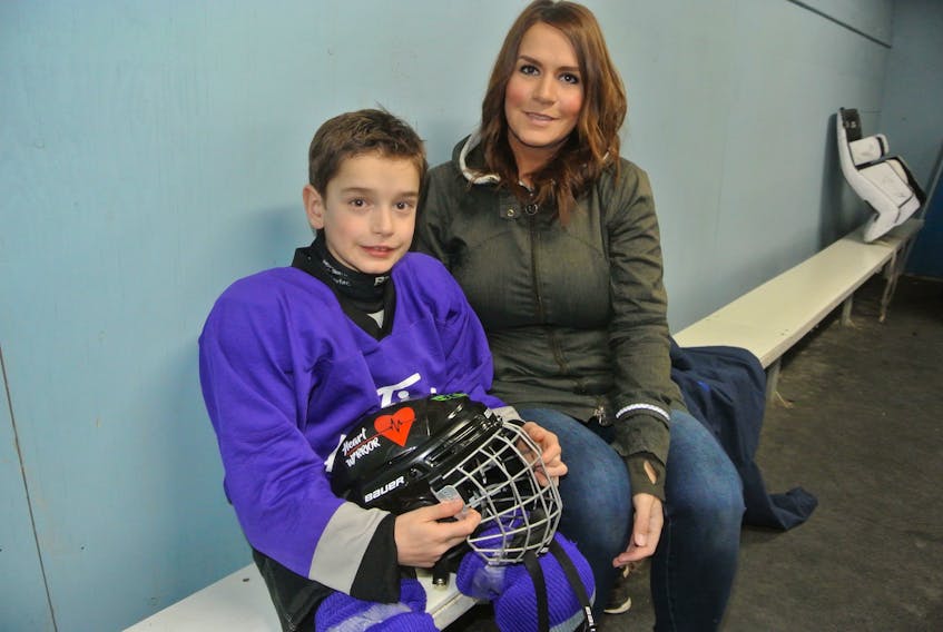 Brody Kouwenberg sits with his mother Jennifer at the Oxford Lions Recreation Centre. The eight-year-old Oxford boy is in this first season of minor hockey, despite having a heart defect that requires a pacemaker to keep heart beating.