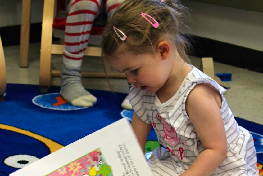 Barbie Mesher’s three-year-old daughter, Ava enjoying a book at the Cartwright Public Library.