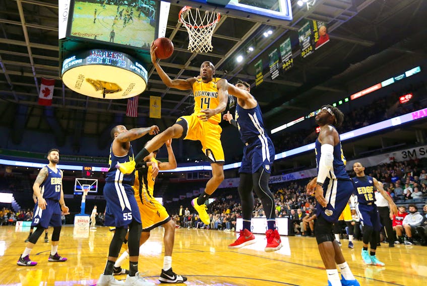 Marcus Capers of the Lightning is fouled by Satnam Singh of the St. John's Edge (right) as he tries for a reverse layup during the NBL Canada season-opener for both teams at the Budweiser Gardens in London. Ont., on Sunday. The defending champion Lightning won 107-103. — Mike Hensen/The London Free Press/Postmedia Network