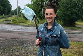 Kali Hines, program coordinator with the Great Nova Scotia Pick-Me-Up Program is seen scooping up a non-medical face mask in the downtown Truro area. Such personal protection equipment items are increasingly being improperly discarded.