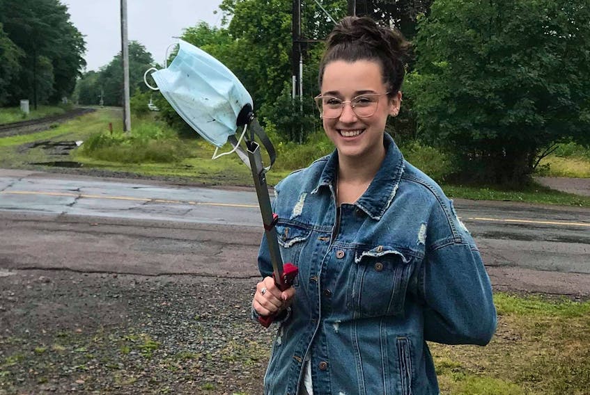 Kali Hines, program coordinator with the Great Nova Scotia Pick-Me-Up Program is seen scooping up a non-medical face mask in the downtown Truro area. Such personal protection equipment items are increasingly being improperly discarded.