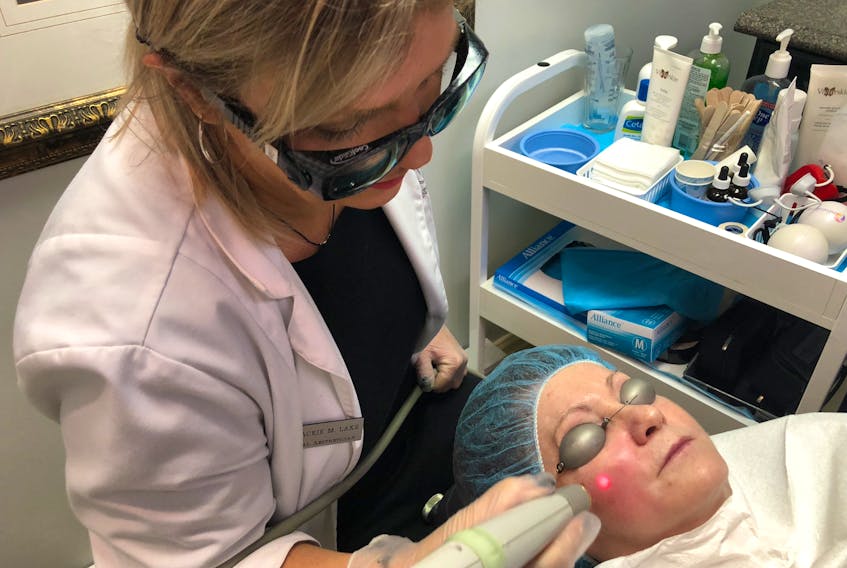 Medical aesthetician Jackie Lake uses laser genesis to help reduce reds and congestion in the skin. -- Maria Afonso
