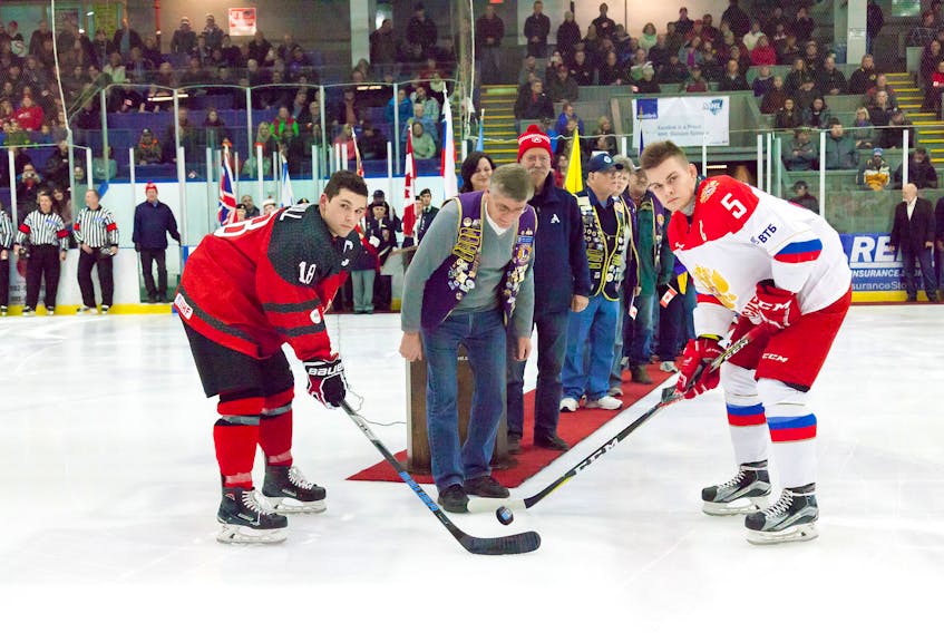 Lion Steve Butler drops the puck between the Canada West and Team Russia captains prior to the Friday, Dec. 8 World Junior A Challenge exhibition game at the Amherst Stadium.