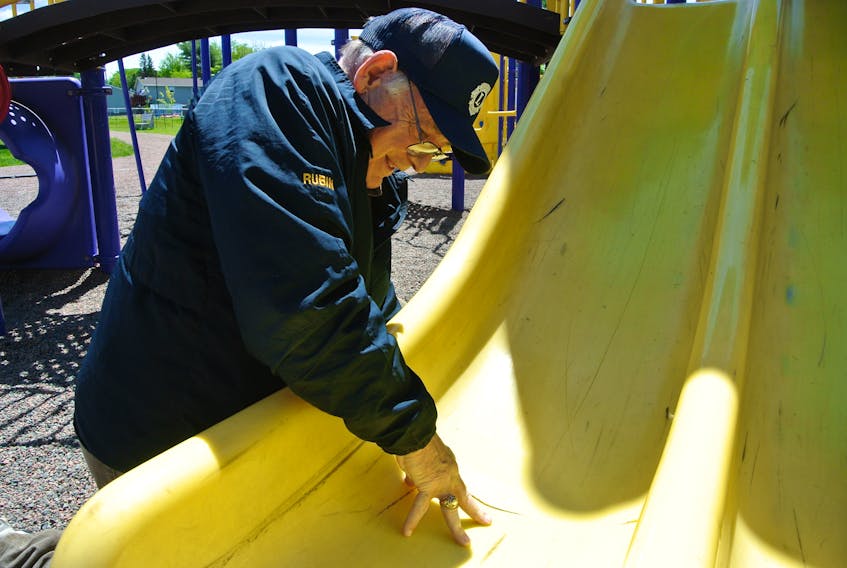 Rubin Millard, park committee chairman for the Amherst Lions Club, looks over damage to a slide on the children’s playground at the Lions Park on Hickman Street. It’s the latest round of vandalism at the park.