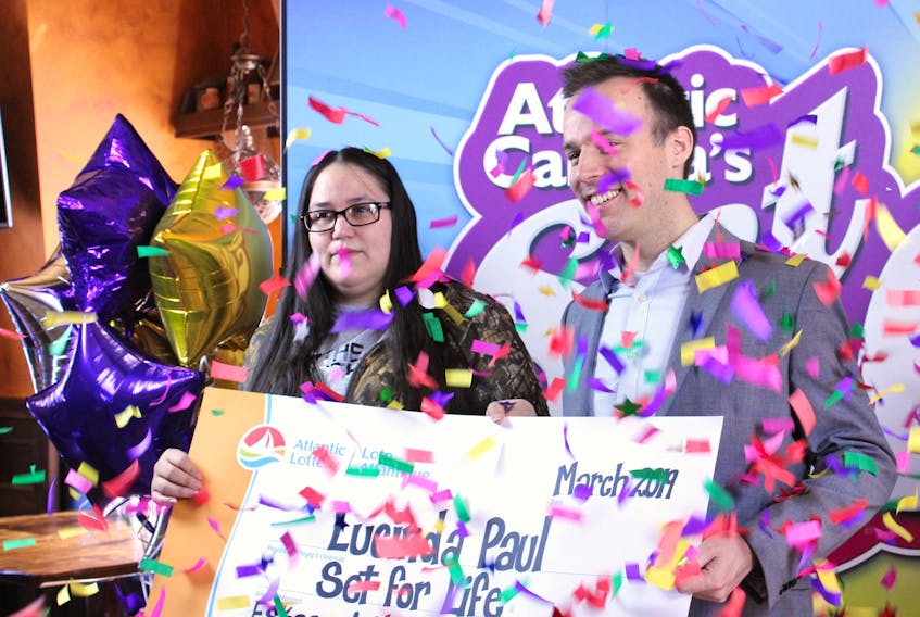 Lucinda Paul, left, of Eskasoni accepts her Set for Life lump sum win of $675,000 from Atlantic Lottery spokesperson Greg Weston at a celebration hosted by Governor’s Pub in Sydney.