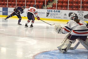 Lauren Barrett of the Cape Breton Lynx, left, fires a wrist shot on King's-Edgehill School goaltender Rachel Dean, right, while Heidi Harvie attempts to block the shot during Maritime Under-18 Female Major Hockey League exhibition action at the Membertou Sport and Wellness Centre on Tuesday. KES won the game 2-1.