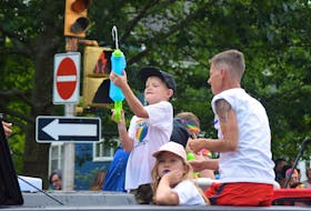 A boy fires his water gun as he rides on one of the many carnival floats rolling down Prince Street during the 2018 Truro Pride parade on Saturday.