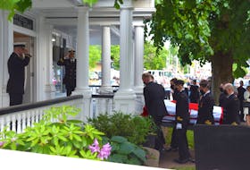 Black-masked pall bearers carry the remains of Canadian Armed Forces Sub-Lieutenant Matthew Pyke into the Mattatall-Varner Funeral Home after arriving from the Halifax Stanfield International Airport Thursday evening.