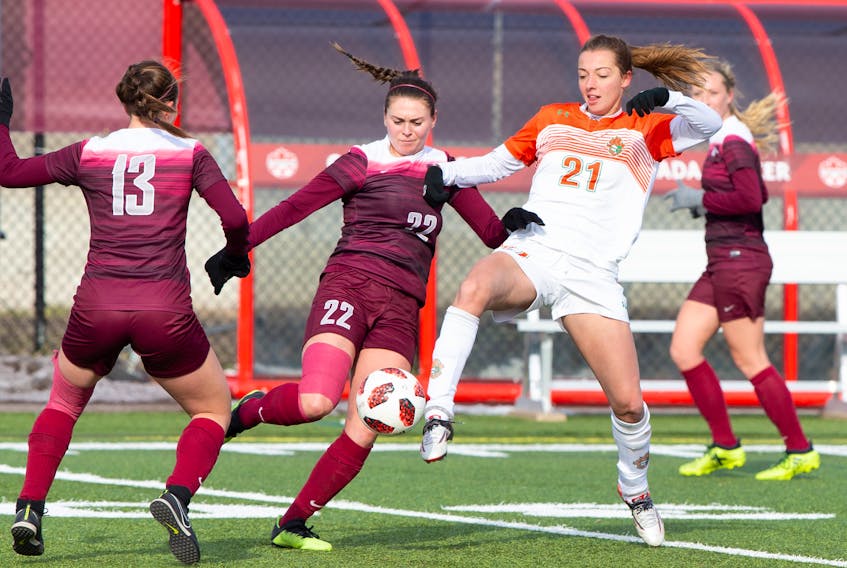 Cape Breton's Rachel Leck battles for the ball against McMaster's Mary Craig (22) and Claudia Continenza (13) during the U Sports women's soccer bronze medal match in Ottawa. Leck scored the lone goal in the Capers' 1-0 victory on Sunday.  U SPORTS PHOTO
