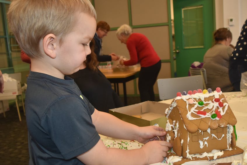 Kai Hayden, 4, enjoyed making a gingerbread house at the Museum of Industry on Saturday, Dec. 8