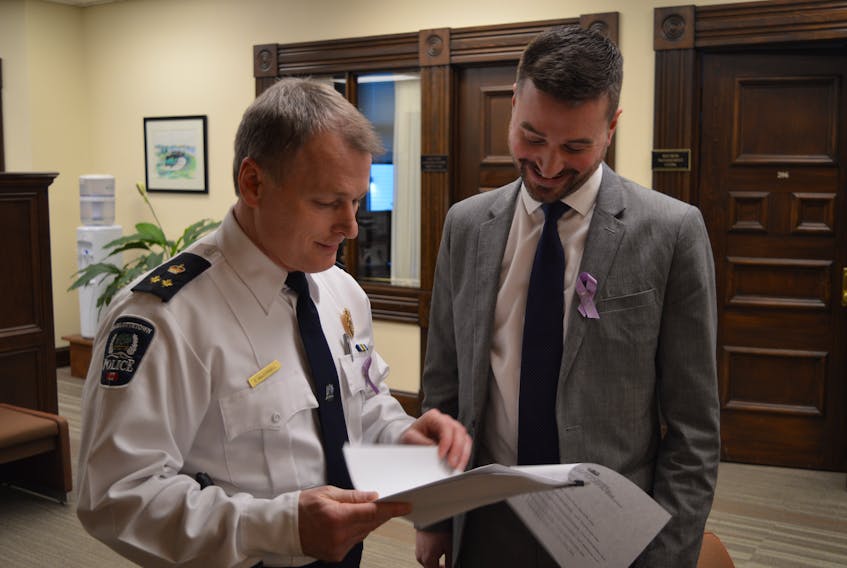 Charlottetown Police Services Deputy Chief Brad MacConnell, left, and Zac Murphy, a board member with Charlottetown’s youth advisory board, discuss changes to the city’s taxi bylaw prior to city council’s monthly public meeting in Charlottetown on Monday night.