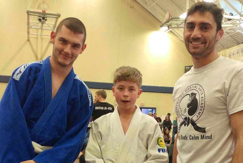 Summerside Martial Arts Academy head coach Jason Saggo, right, congratulates Ty Linkletter, centre, and Brendan Pollon on their efforts at the Abhaya Open in Windsor, N.S., recently. Linkletter, 13, competed in his first Brazilian Jiu-Jitsu tournament while Pollon competed in the Adult Division.