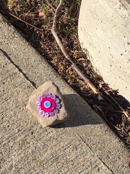 These rocks rock!

It's been a difficult spring but sometimes a tiny gesture can brighten someone's day.  Last weekend, while out for a stroll in Port Hood NS, Elvi and Georg Kargoll found several rocks, of different shapes and sizes, decorated with colourful buttons. It appeared that a kind-hearted soul decided to place these special stones along the sidewalk to cheer people up. They don't know who made them and put them there, but they enjoyed them very much!