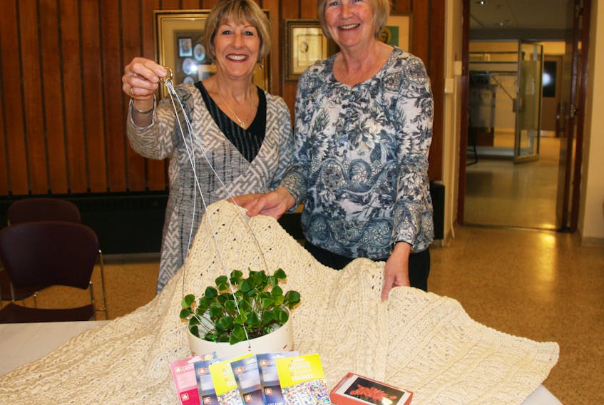 St. Martha’s Regional Hospital auxiliary president Nancy MacEachern (left) and Mayfest chair Gill Hillyard display a few of the items available through the event’s raffle draw; including an Afghan made by Eileen Aucoin, a hanging basket and gift cards from the Red Sky Gallery and Home Hardware gift cards.