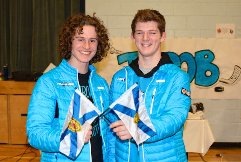 Nova Scotia men’s hockey player Jacob Melanson (right), along with Nova Scotia snowboarder Jake Adams, proudly waved the Nova Scotia flag during a pep rally at Spring Street Academy school in Amherst before traveling to the Canada Winter Games in Red Deer, Alta.