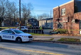 Halifax police confer at the scene inside an cordoned-off area at the intersection of Lady Hammond Road and Robie Street where a man's body was found early Monday morning, Nov. 30, 2020.