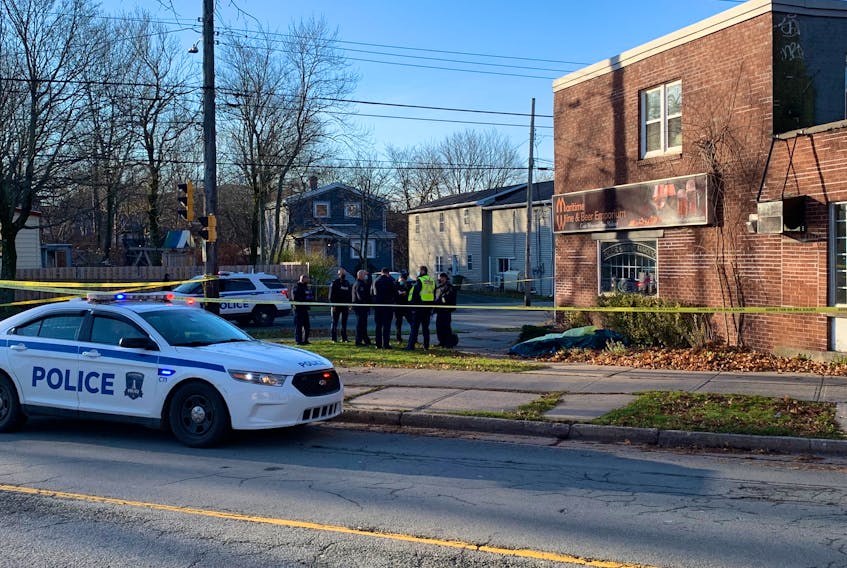 Halifax police confer at the scene inside an cordoned-off area at the intersection of Lady Hammond Road and Robie Street where a man's body was found early Monday morning, Nov. 30, 2020.
