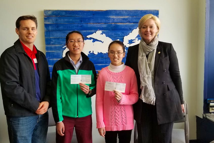 Sean Kirby, executive director of the Mining Association of Nova Scotia, and Cumberland North MLA Elizabeth Smith-McCrossin present cheques to sisters Fumairia and Christelina Laureijs of Pugwash, who tied for second place in the Best 30-second Commercial category for the Mining ROCKS! Video Contest.
