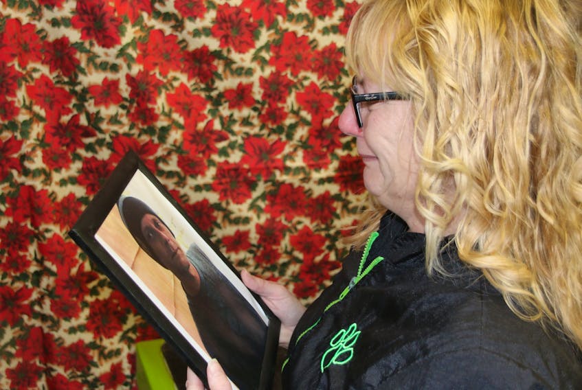 Susan Robben struggles to hold back tears as she looks at a photo of her son, Peter Anthony (Tony) Walsh, who has been missing since August.