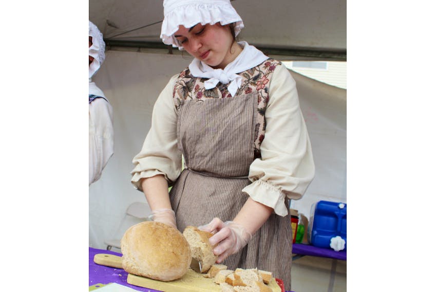Jessica MacLeod of Roma at Three Rivers slices a piece of traditional soldier's bread during the DiverseCity Multicultural Street Festival held in Montague in July 2018. The site offers a glimpse into life in the 1730s French P.E.I. settlement.