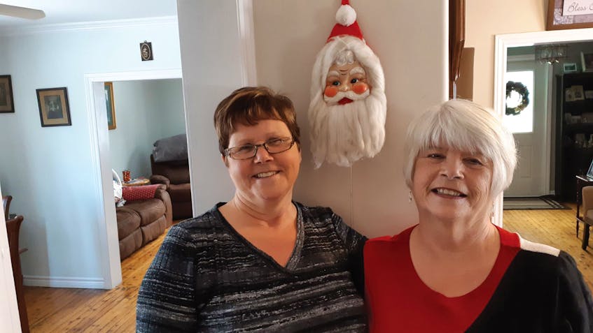Sisters Jean (Peddle) FitzPatrick and Betty (Peddle) Ryan are shown here in front of the Santa face their parents bought when raising their young family.
