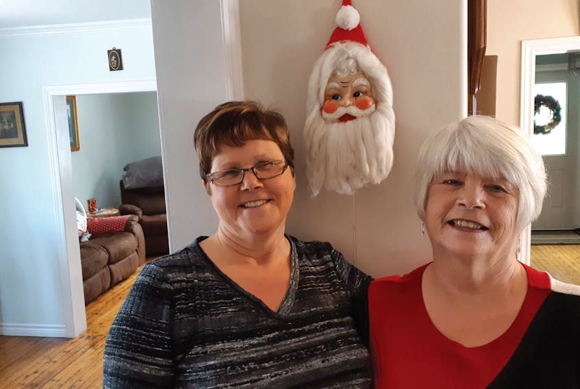 Sisters Jean (Peddle) FitzPatrick and Betty (Peddle) Ryan are shown here in front of the Santa face their parents bought when raising their young family.