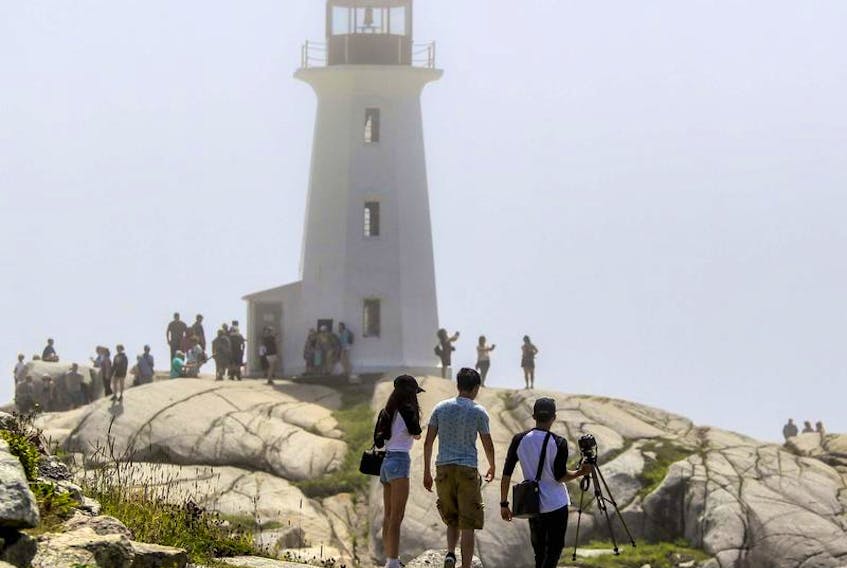 Tourists walk toward the lighthouse at Peggys Cove. Tourism Nova Scotia data shows the shared economy is a fast-growing segment of the provincial tourist market.