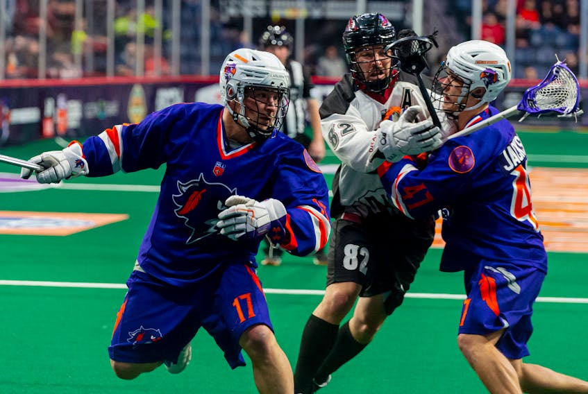 Halifax Thunderbirds' Ryan Benesch, left, with the help of teammate Kyle Jackson, eludes Colorado Mammoth defenceman Joey Cupido during a National Lacrosse League last Saturday at Scotiabank Centre.   HALIFAX THUNDERBIRDS 
