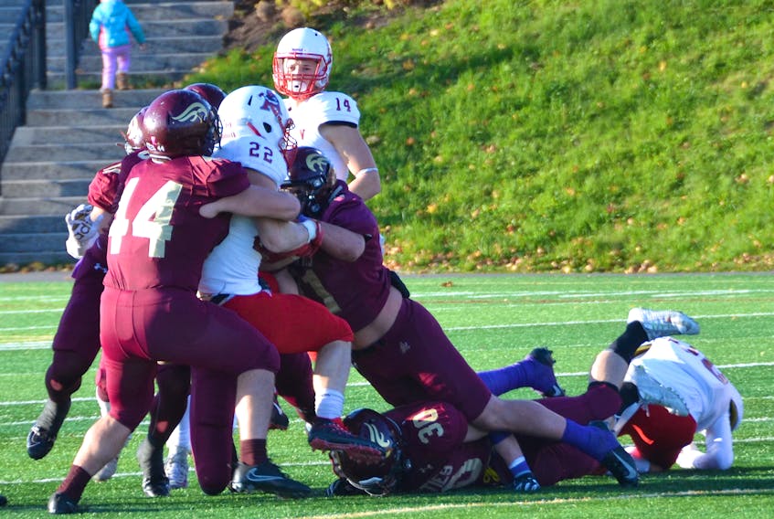 The Mounties’ defense stood strong once again on Saturday, although the team fell 33-31 to the visiting Axemen. Above, Acadia running back Cole Estabrooks has no place to turn as several Mountie defenders converge on him.