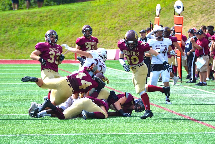 A Saint Mary’s player goes down under a pile of Mounties in Saturday afternoon’s game at Alumni Field.