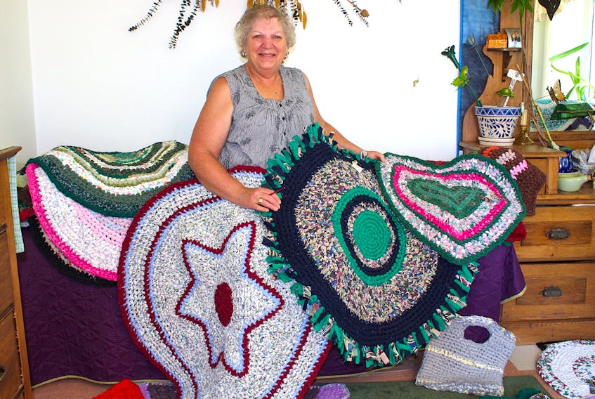 Gail Chapman displays just a few of the more than 200 rag rugs she has made using used linens and discarded clothing. The retired banker puts her crocheting experience together with a lot of imagination - and patience - in the designing and stitching of her creations.