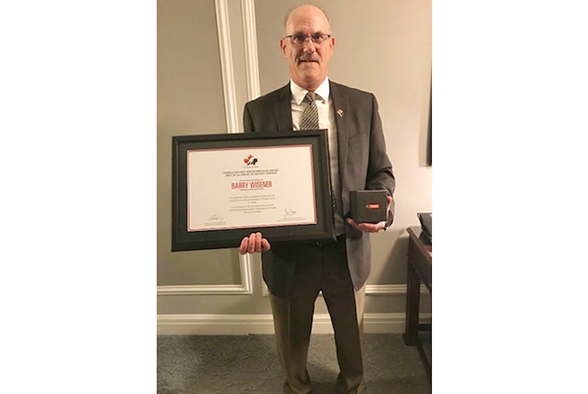 Barry Wisener, formerly of Pictou, with his award from Hockey Canada.