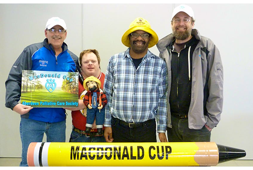 Mike MacNaughton, left, and Ian Bos, far right, got some help from Summer Street Industries clients Willie O’Brien and Allister MacLean, in promoting the 18th annual MacDonald Cup Fore Palliative Care golf tournament, which will be held in July.